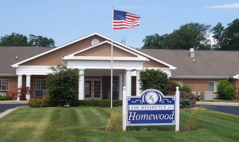Front view of Homewood Health Campus with columns, sign, and flag.