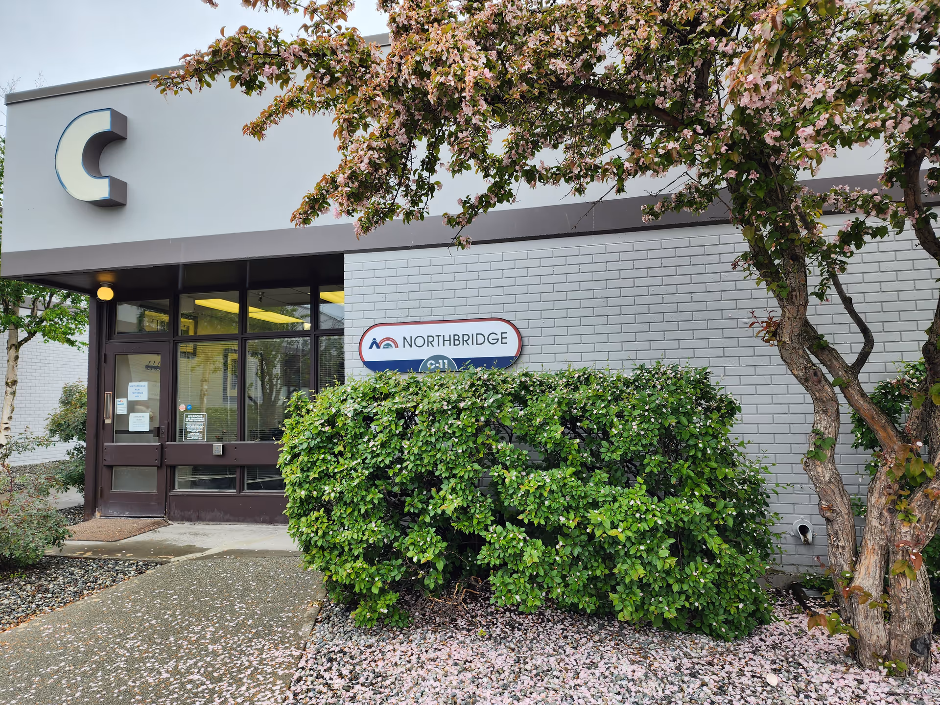Front entrance of Northbridge senior living facility with sign and greenery.
