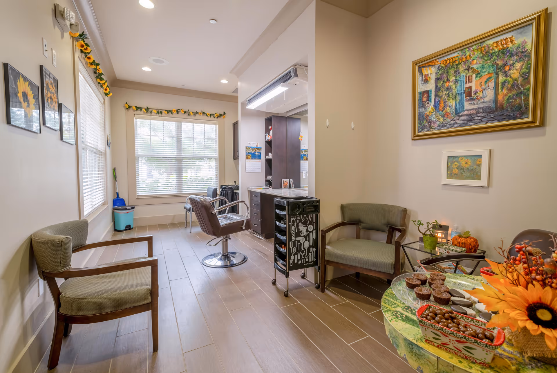 Diamond Oaks Village common lounge with chairs, a hair styling chair, and a table of treats.