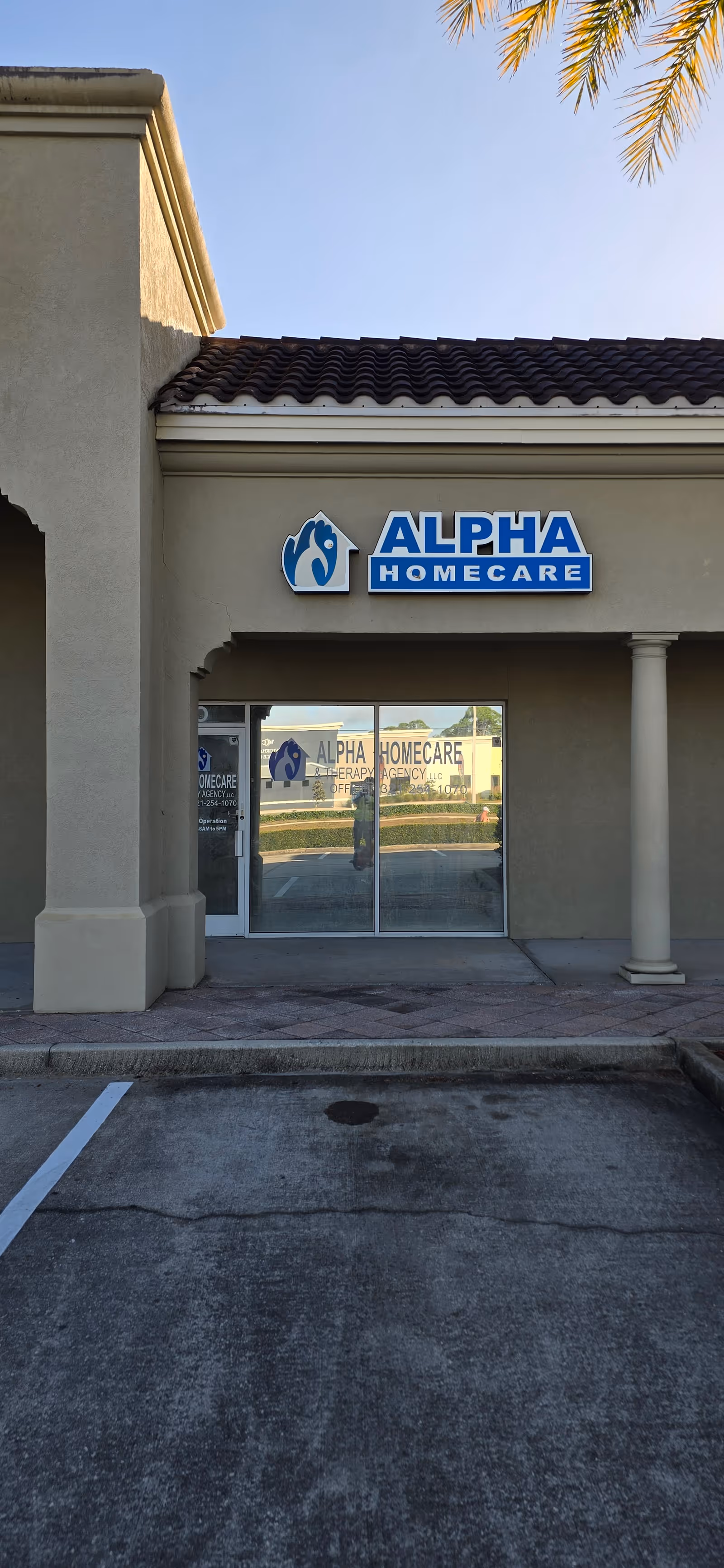 Exterior view of Alpha Home Care building entrance with glass doors and sign.