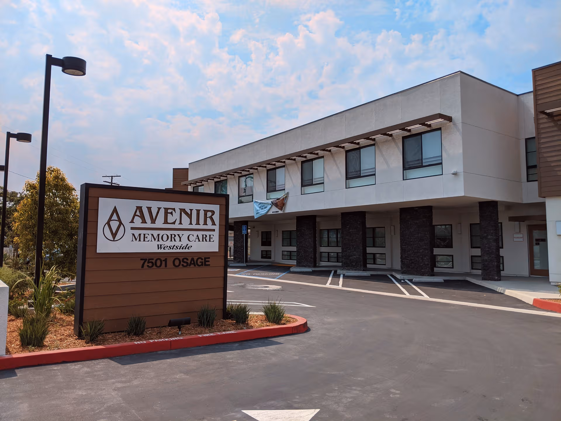 Exterior view of Avenir Memory Care Westside building with sign and parking area.