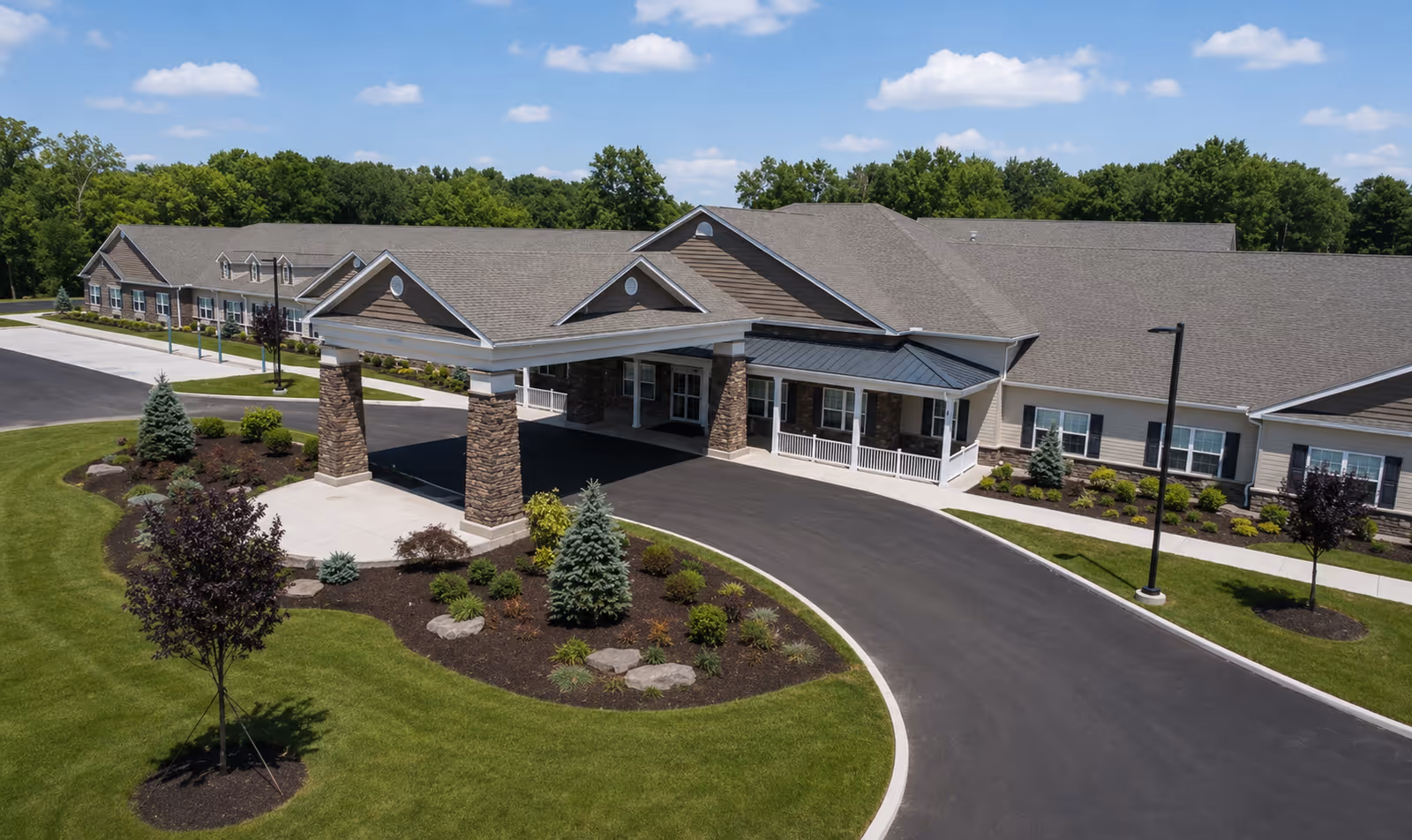 A single-story senior living facility with a curved driveway and landscaped entrance.