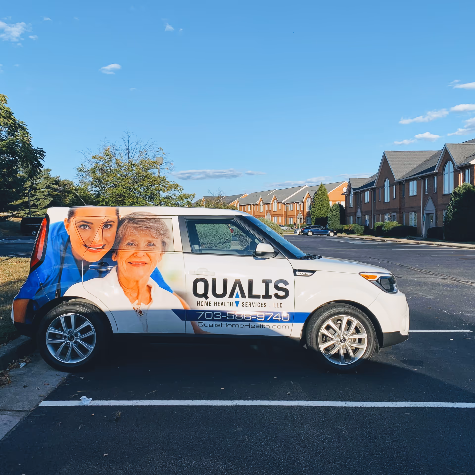 Qualis Home Health Services branded van parked in a suburban lot with houses.
