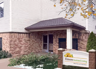 Exterior of Elmore Assisted Living facility with brick facade and front entrance canopy.