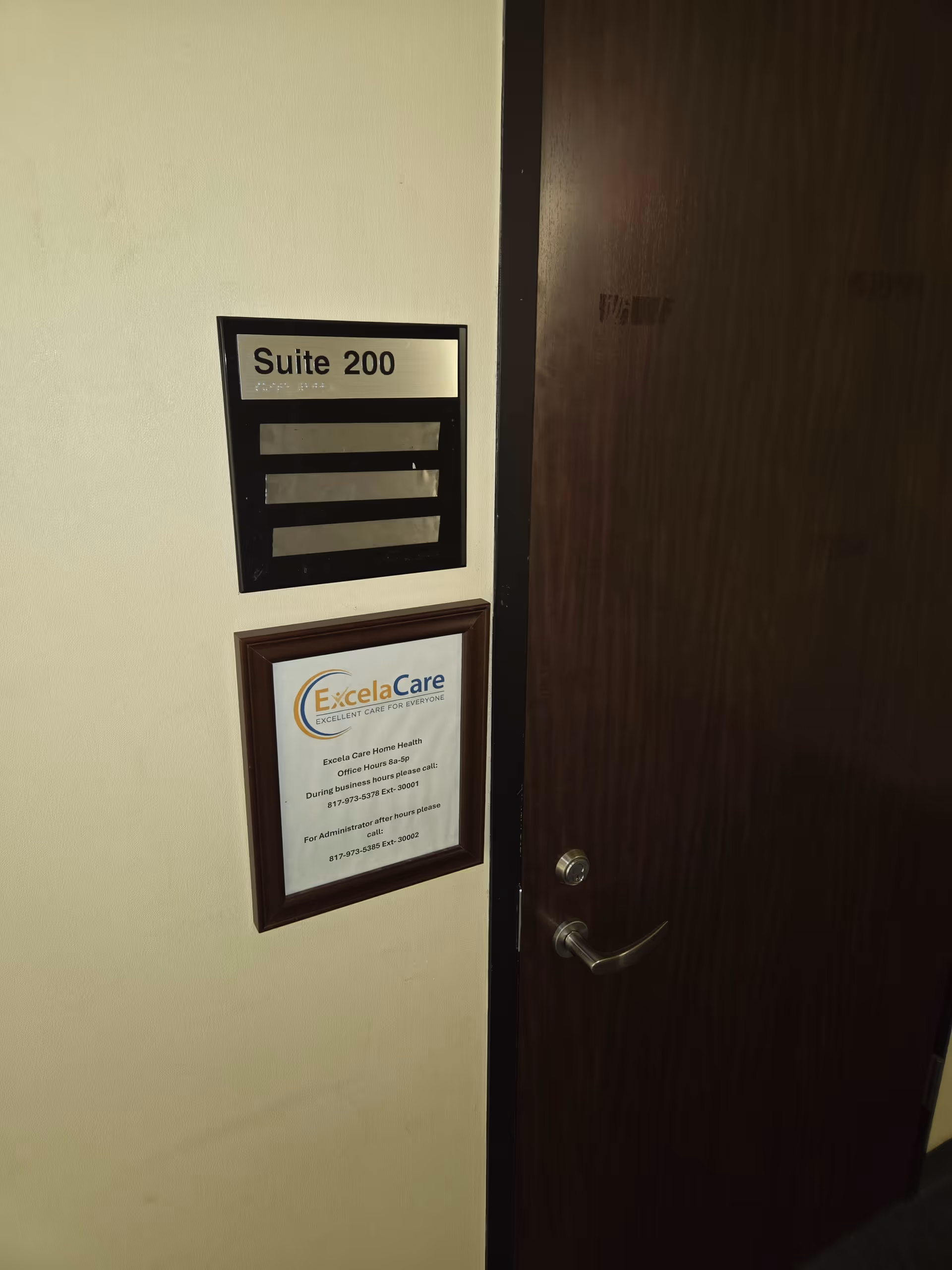 Interior hallway view with a door labeled Suite 200 and a framed ExcelaCare plaque.
