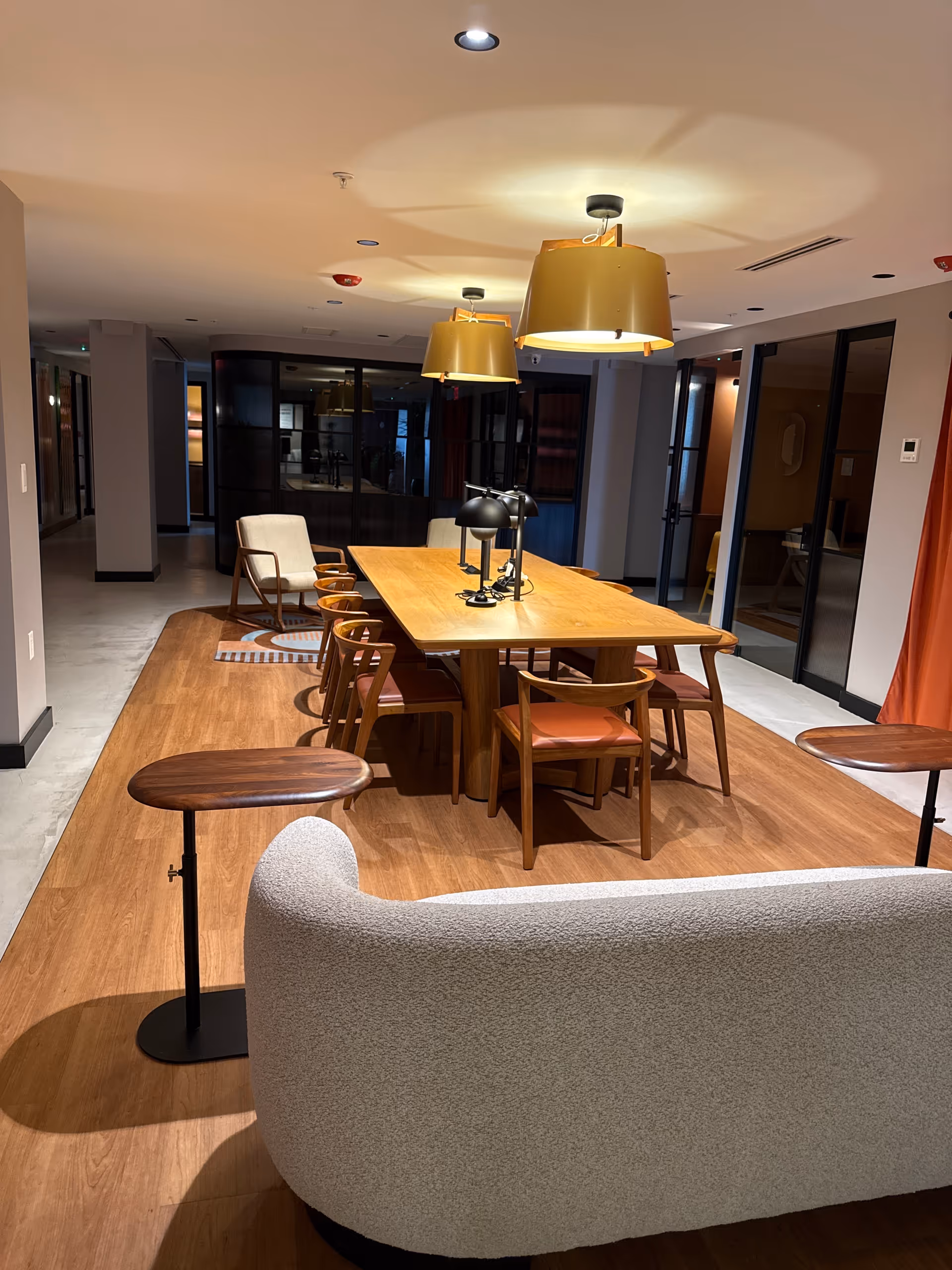 A modern dining area in a senior living facility with a long wooden table and chairs.