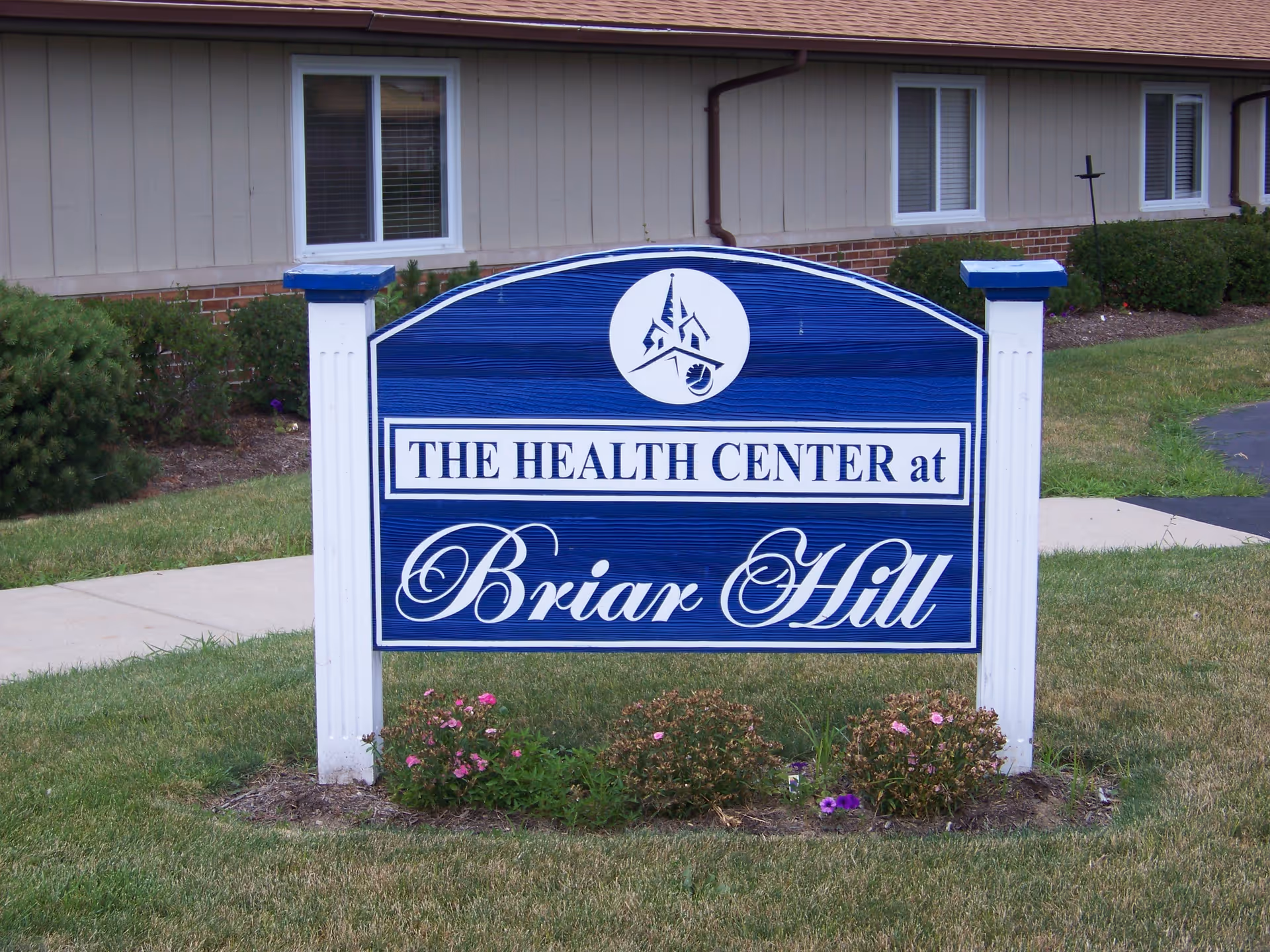Blue sign reads The Health Center at Briar Hill in front of a beige exterior building