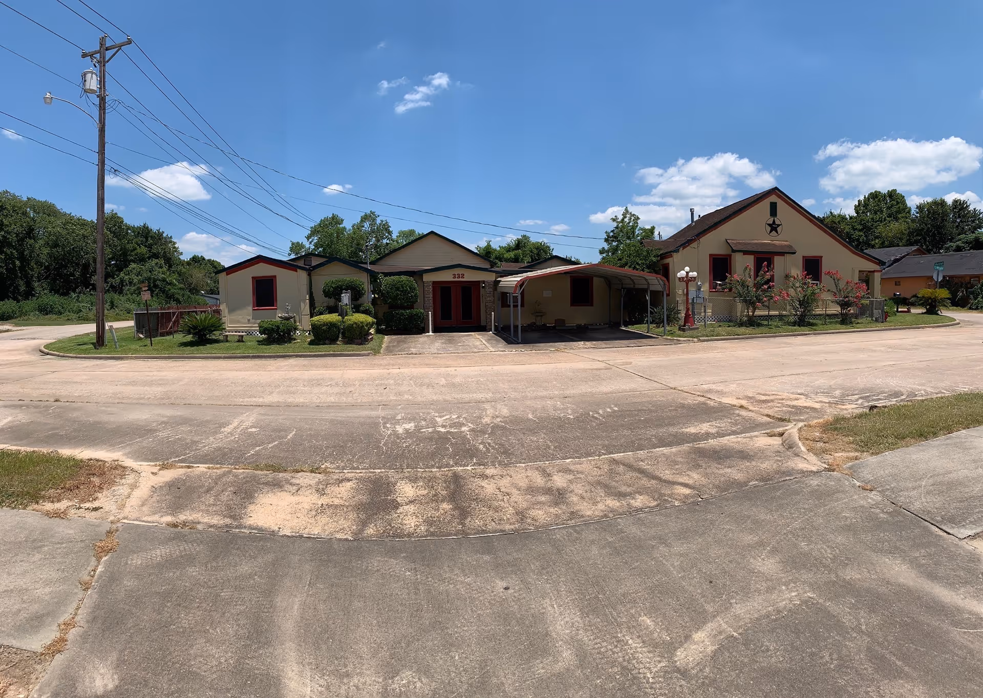 Exterior view of a senior living campus with low-rise buildings and a driveway.