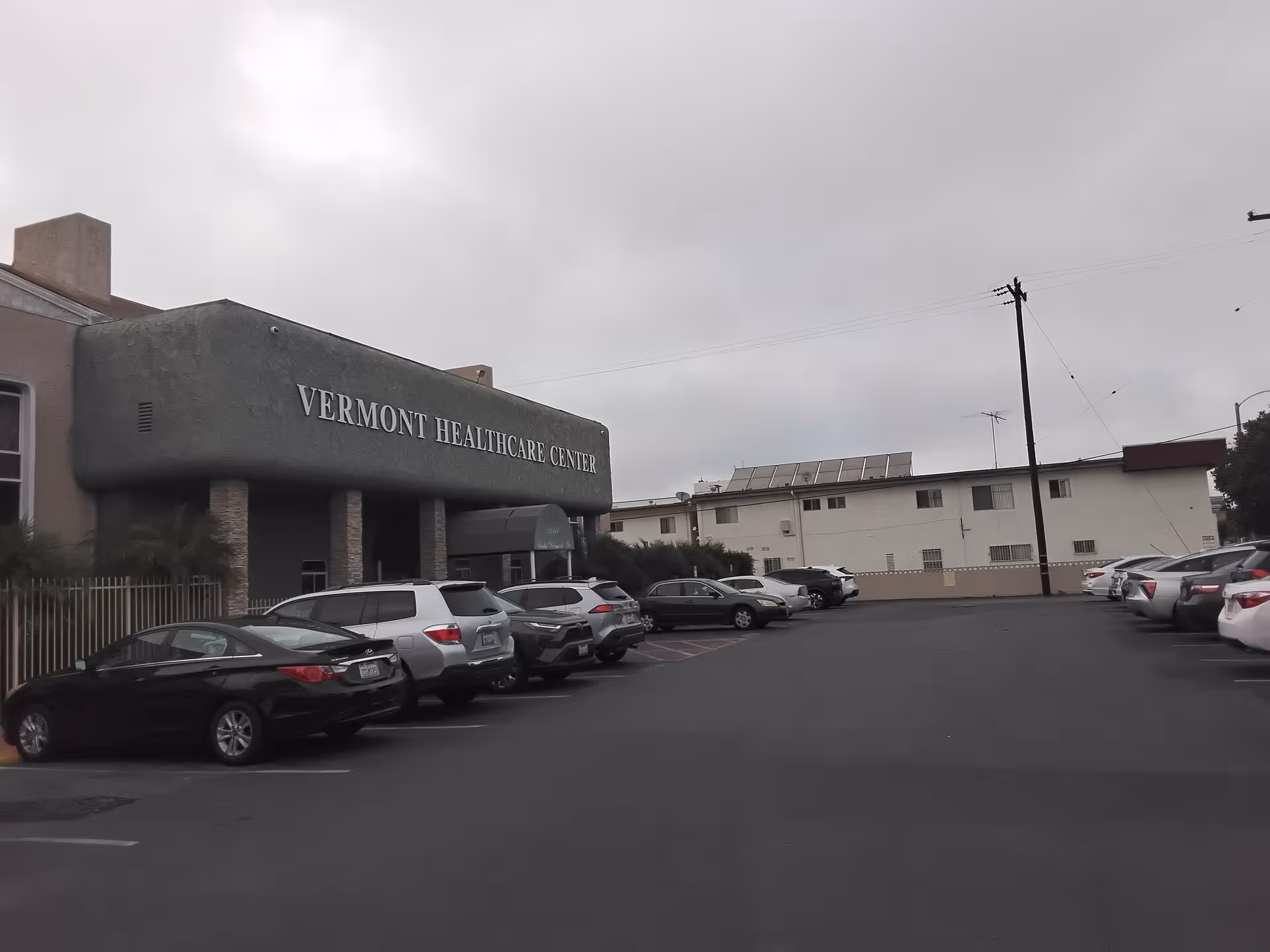 Exterior view of Vermont Healthcare Center with a long parking lot and cars.
