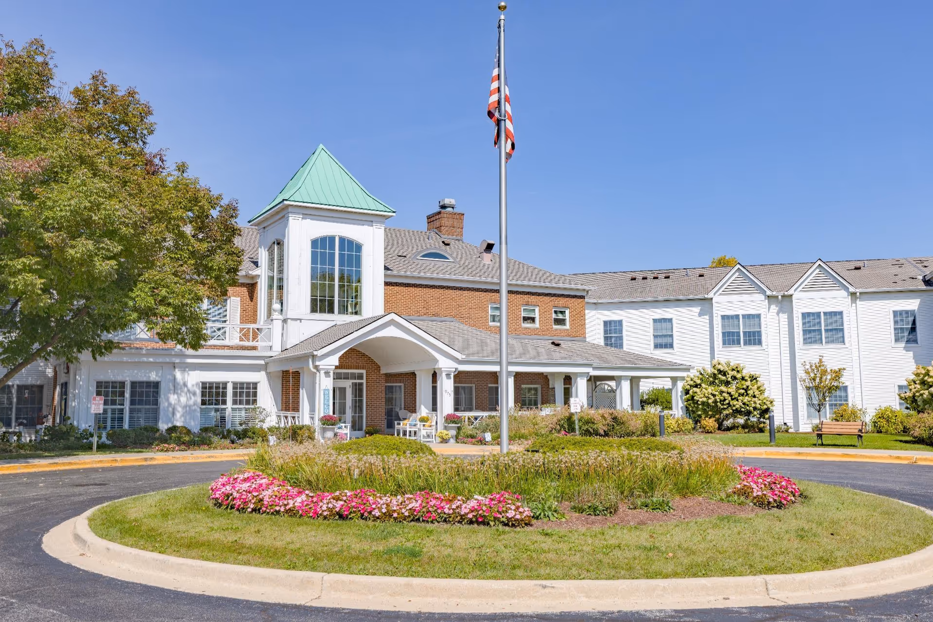 Exterior view of River Glen of St. Charles, a senior living facility with a circular driveway.