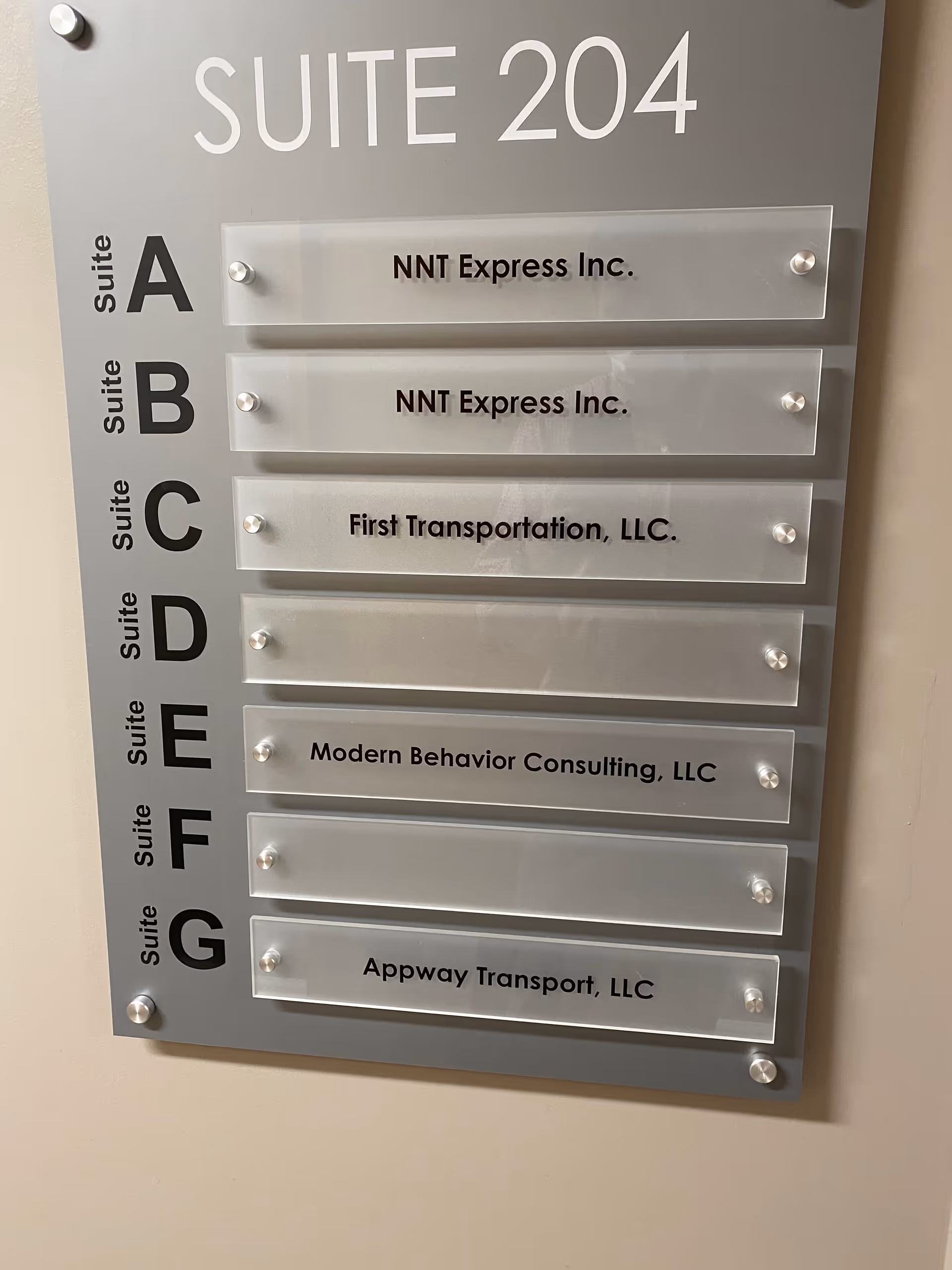 Interior wall directory sign displaying suite numbers and tenant names, including Modern Behavior Consulting, LLC.