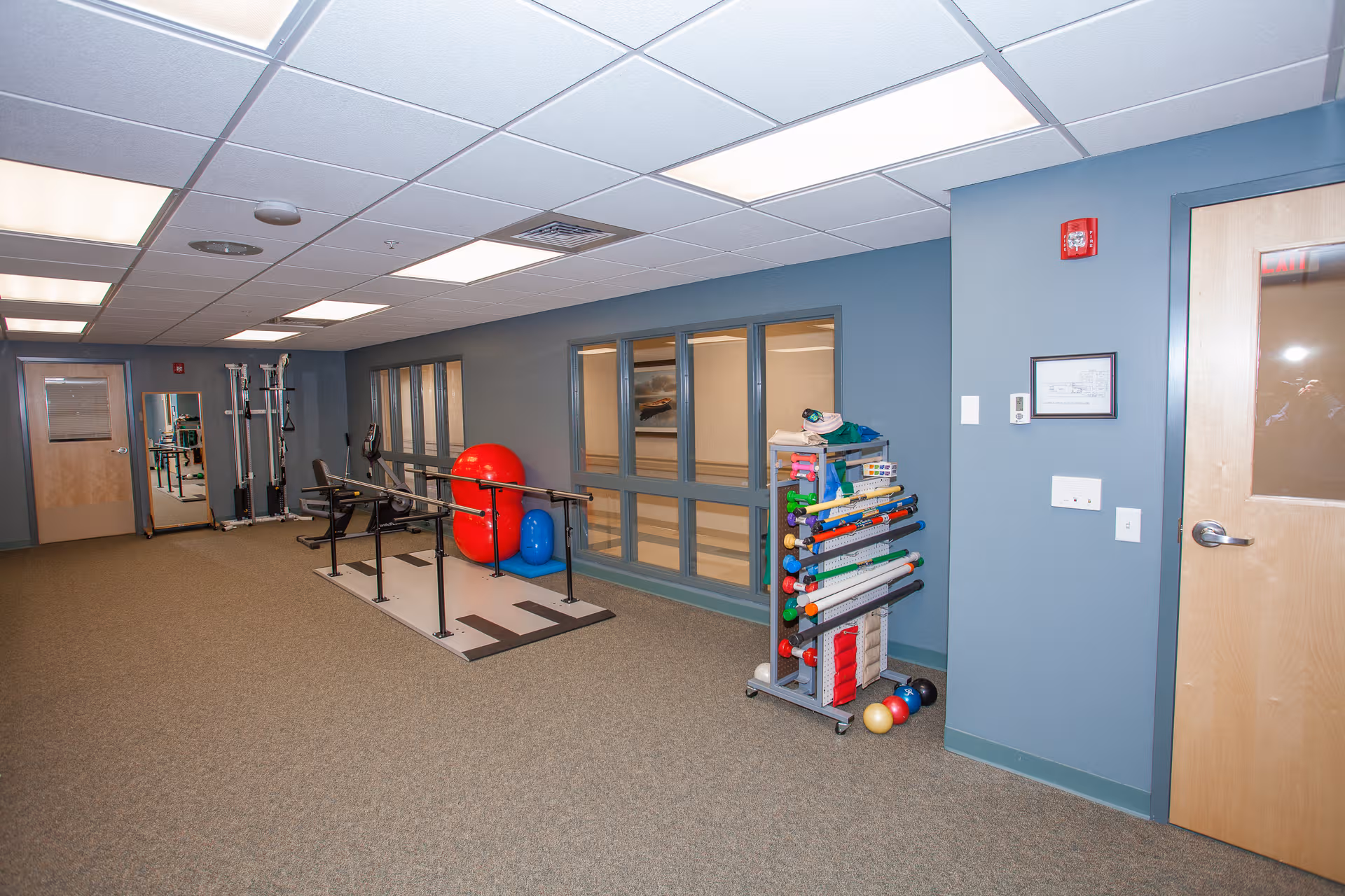 Interior view of Meridian Manor fitness area with weights, mats, and exercise balls.