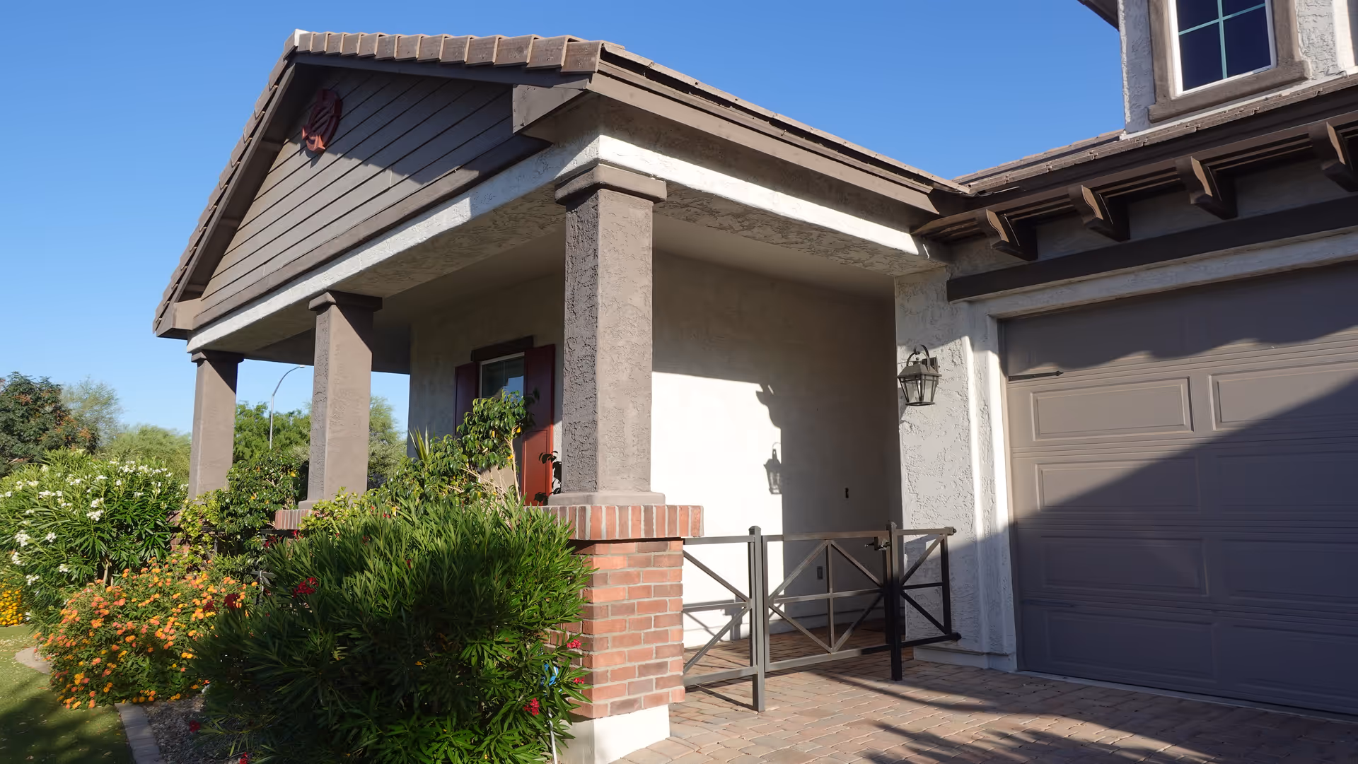 Front exterior of a residential-style facility with a covered entrance and landscaped shrubbery