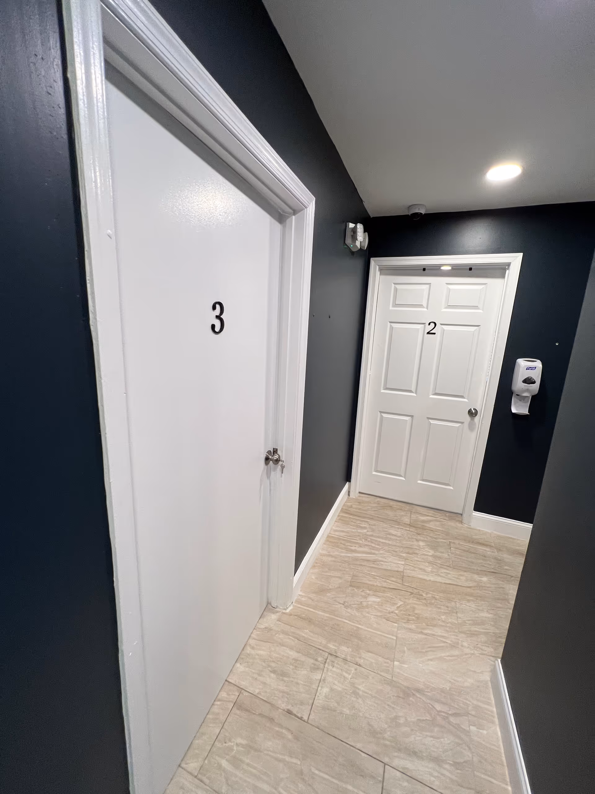 Narrow hallway inside Blessed Angels Home Healthcare Services with white doors labeled 3 and 2.