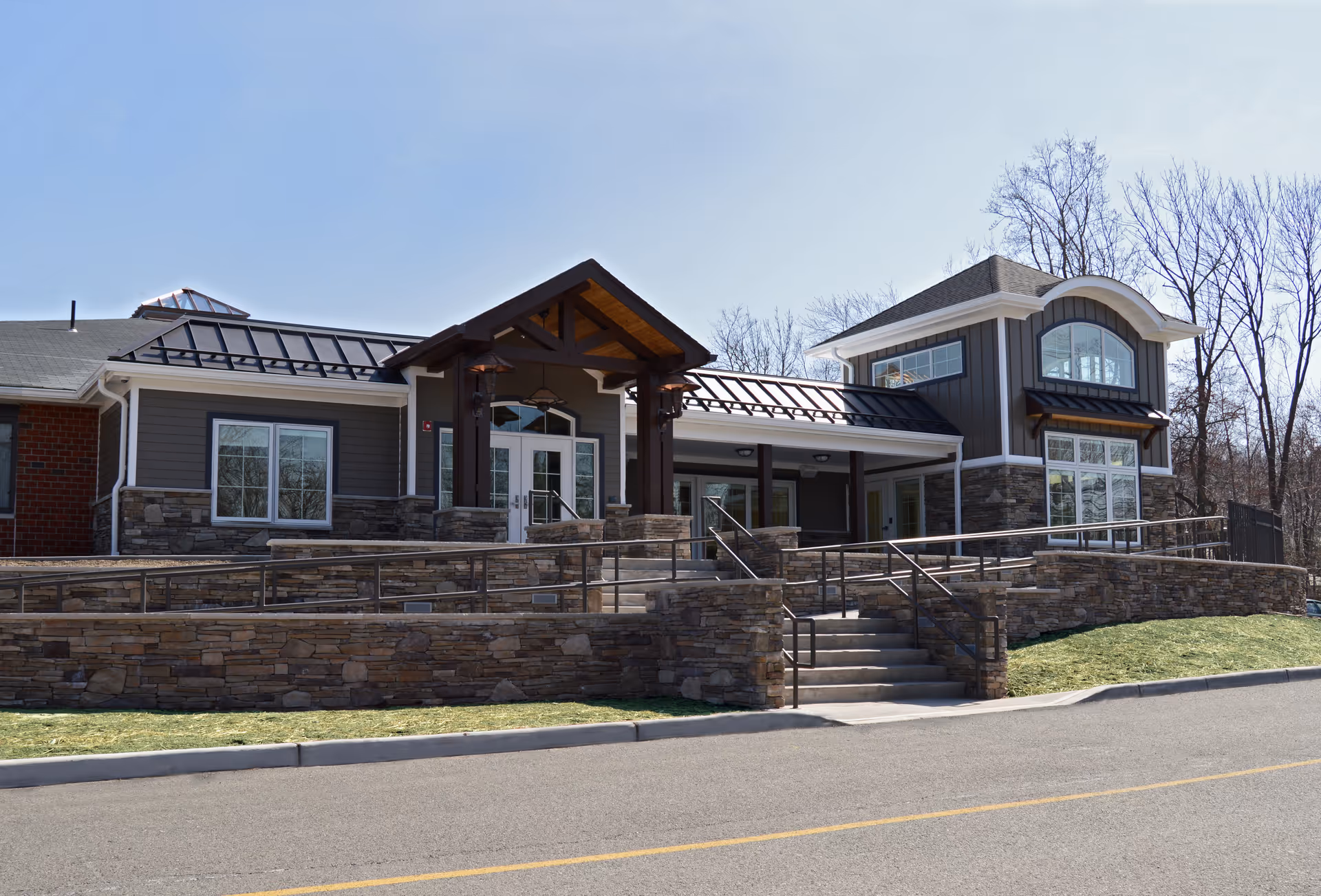 Exterior view of Heritage Manor, a Christian Health Community, with stone facade, entrance stairs and ramp.