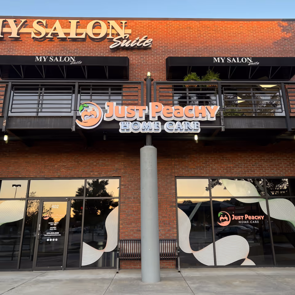 Brick storefront displaying Just Peachy Home Care signage and large windows.