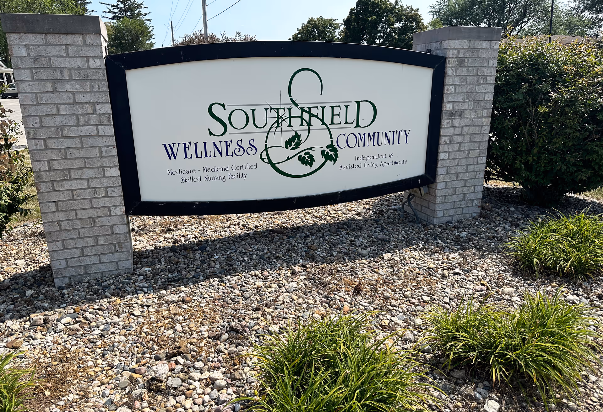 Southfield Wellness Community sign on brick pillars in a rocky front yard.