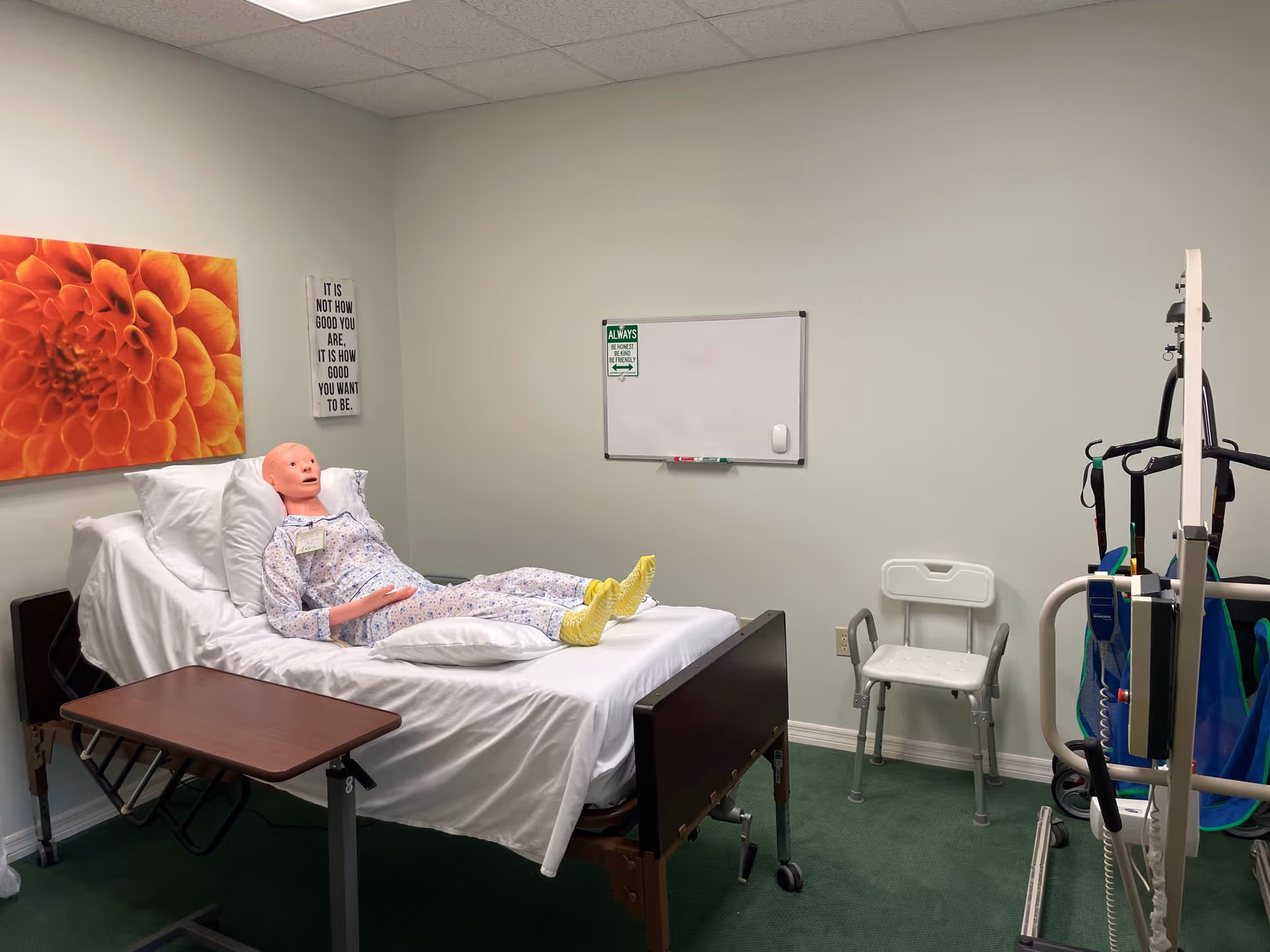 Hospital bed with a mannequin patient in a medical room at a senior care facility.