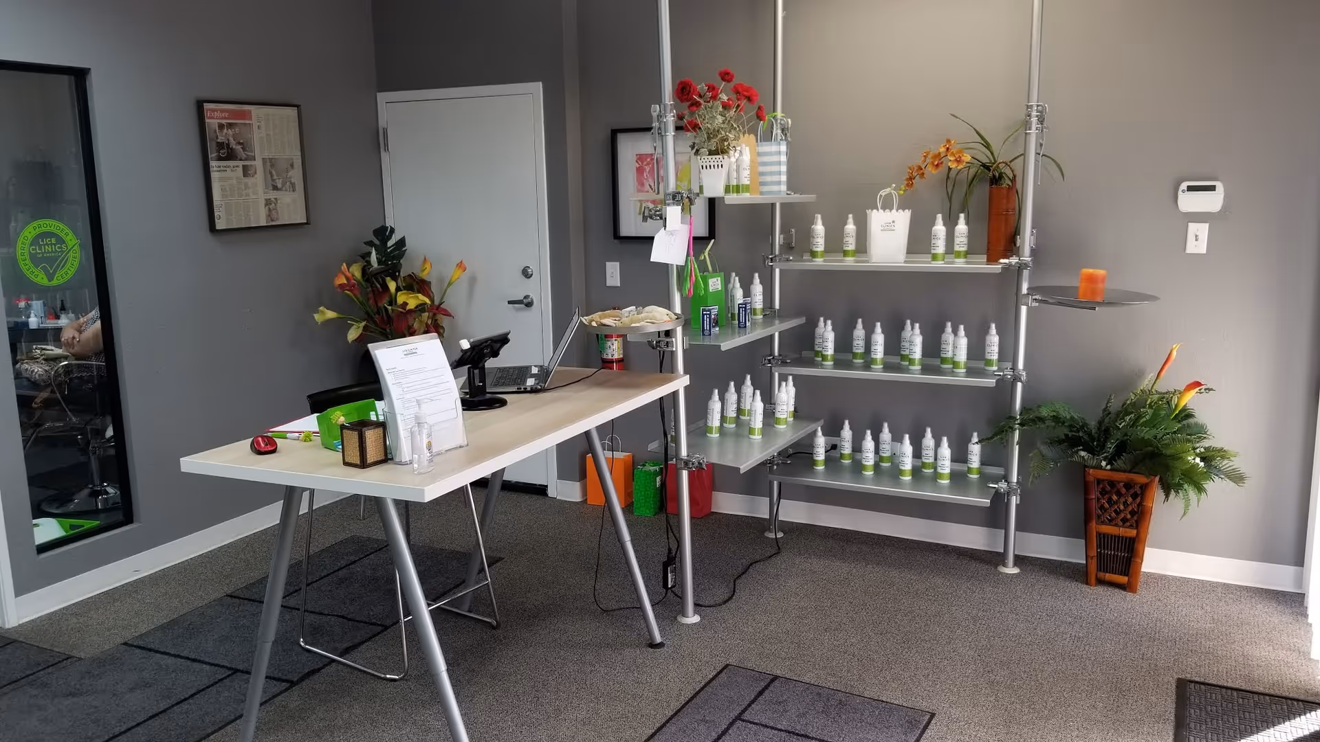 Reception desk with shelves of treatment bottles in California lice clinic interior.