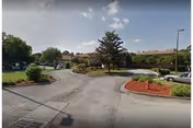 Exterior view of Indian River Center with driveway, landscaping, and parked cars.