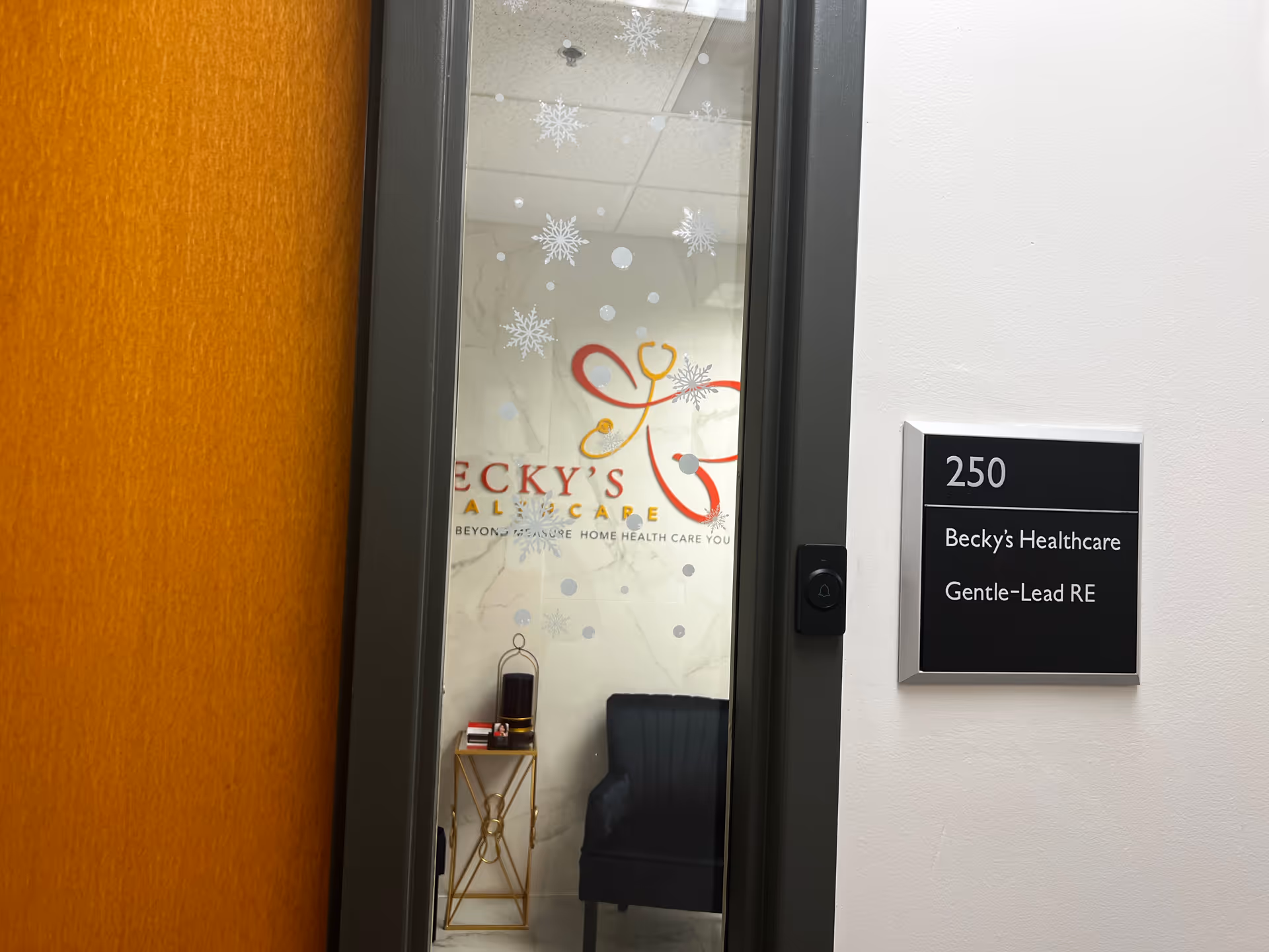 Interior doorway with snowflake decals on glass and a wall plaque reading Becky's Healthcare.