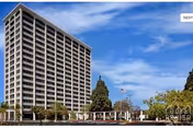 Tall Bethel Towers residential building with balconies, trees, and a blue sky.