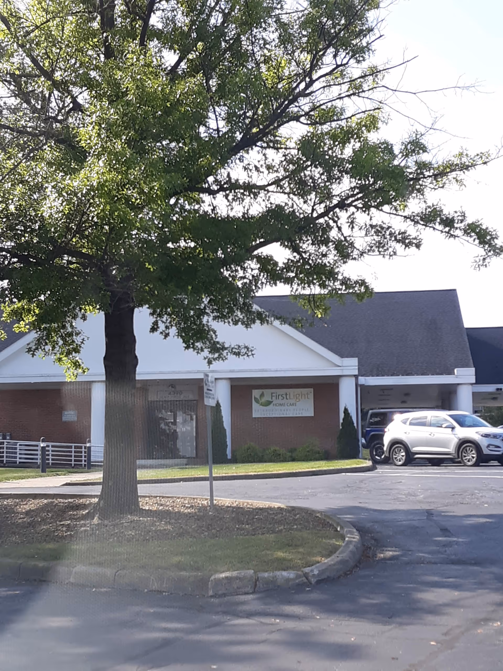 Exterior view of FirstLight Home Care of The Valley with a tree and parked car.