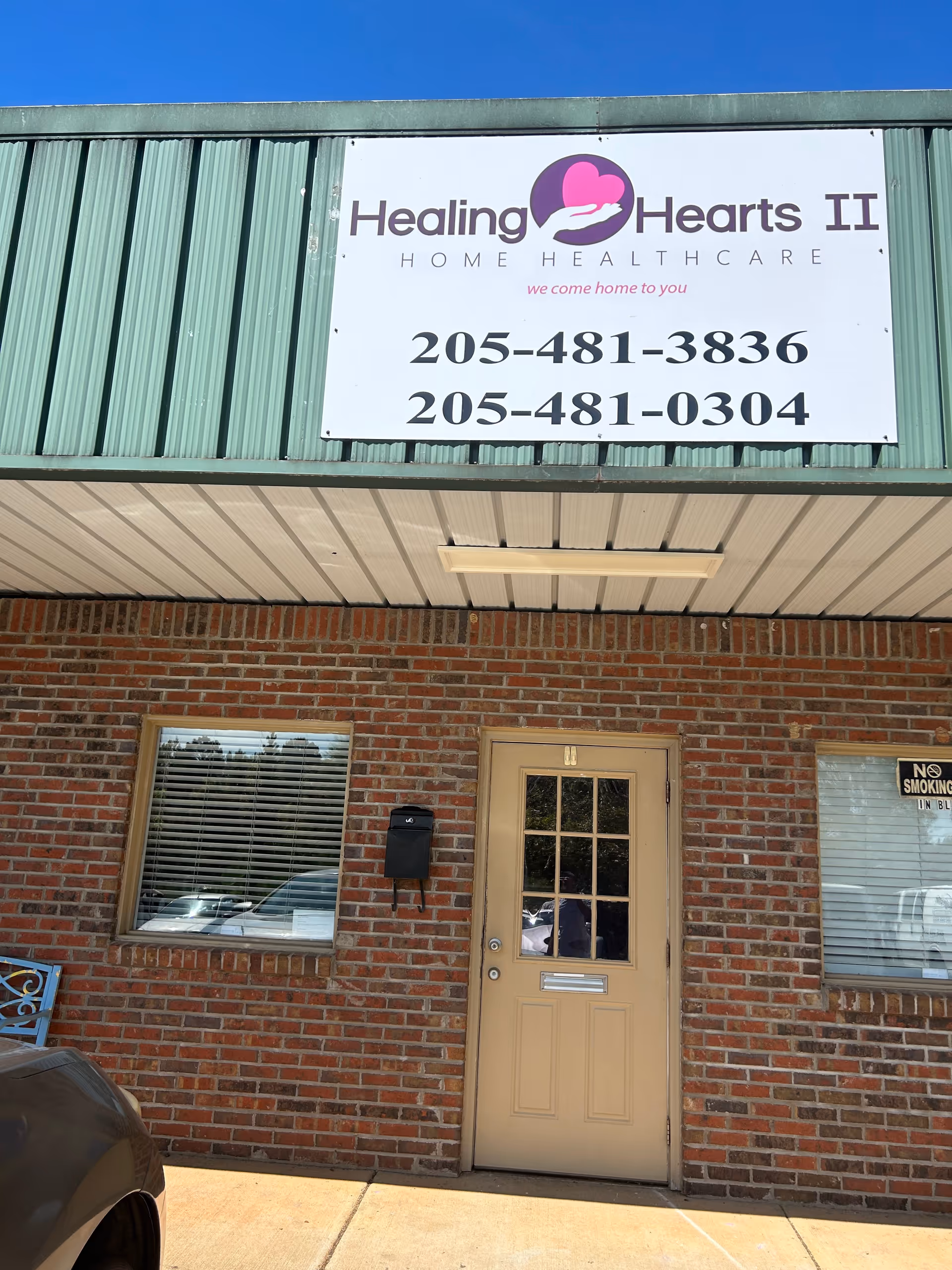 Front view of Healing Hearts II Home Healthcare storefront with brick exterior and door