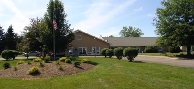Brookdale Painted Post senior living facility exterior with flag, manicured lawn, and driveway.