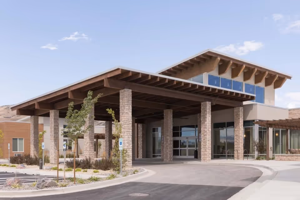 Stone-clad entrance with a large overhang and glass doors at Pointe Meadows