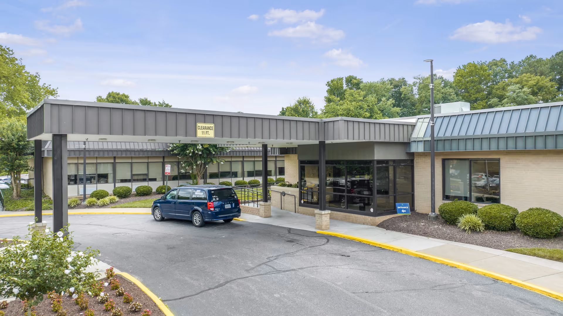 Exterior view of Lexington Court senior living facility with a covered entrance and parking lot