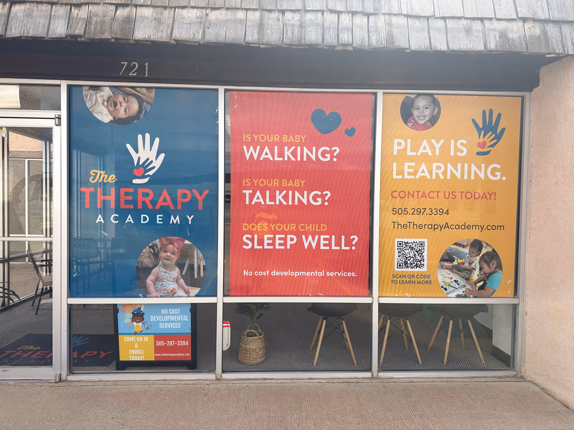Building front storefront with colorful posters advertising The Therapy Academy.