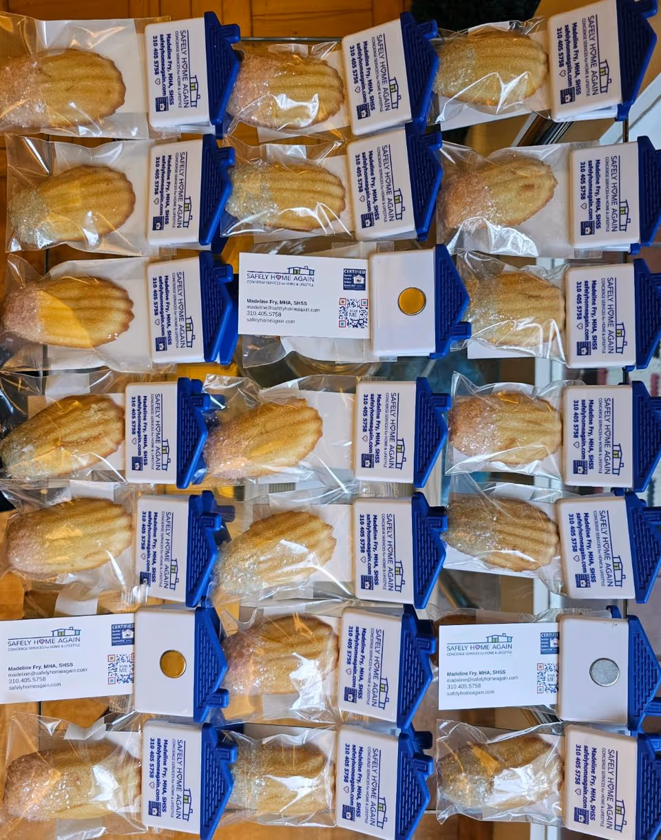 Rows of packaged pastries in blue holders labeled Safely Home Again, LLC, stacked.
