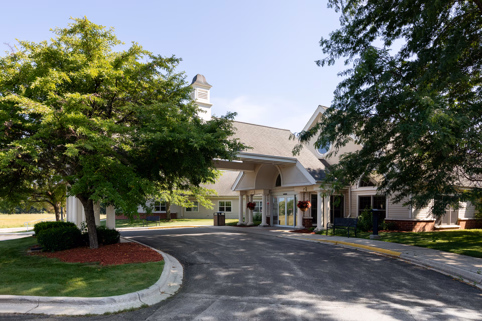 Front view of Virginia Highlands Care and Rehab Center entrance with curved driveway and trees.