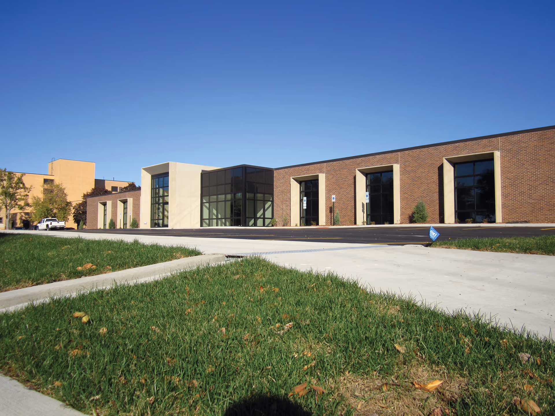 Exterior of HRMC Physicians Clinic with brick facade, glass entry, and blue sky