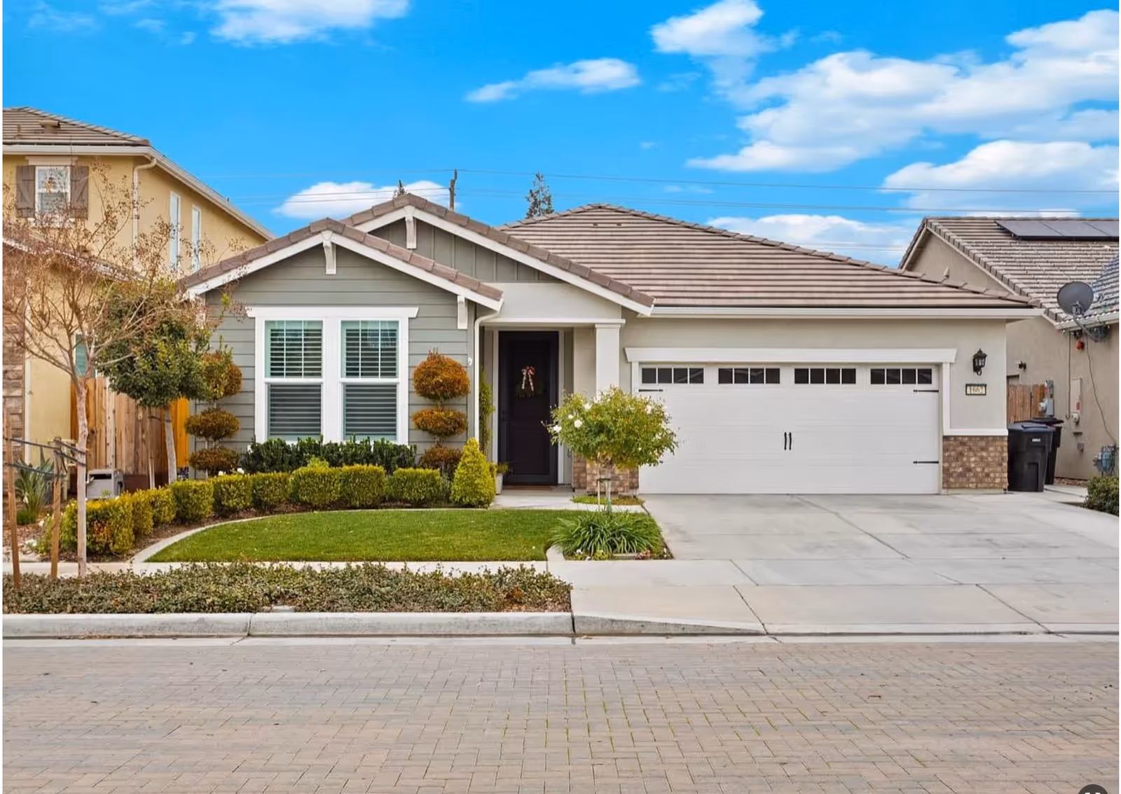 Front view of a single-story suburban home with a two-car garage and manicured yard.