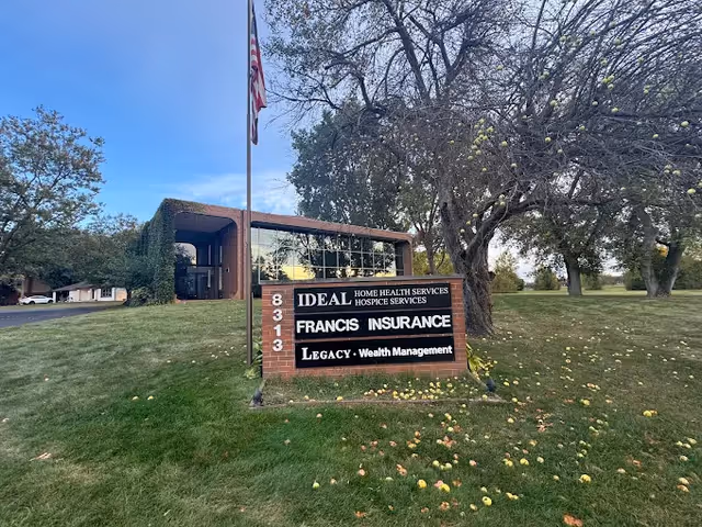 Front exterior of a facility with a sign reading Ideal Home Health Services and a flag.