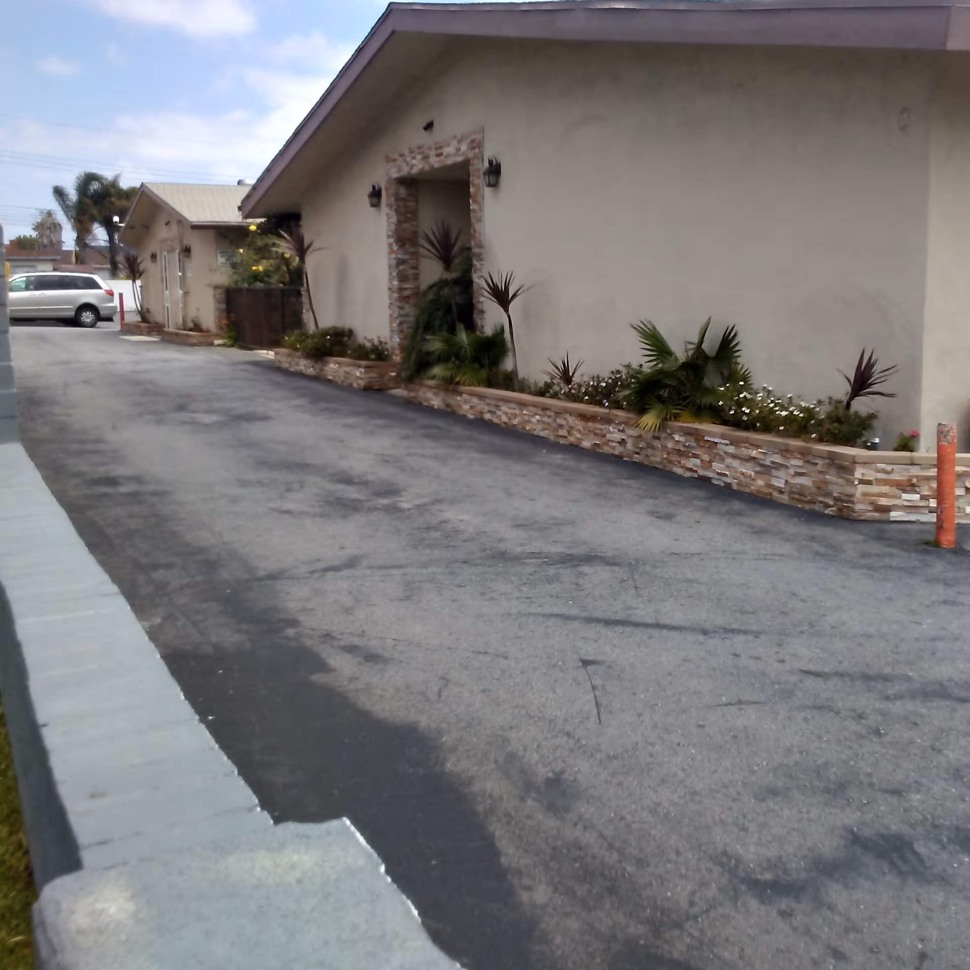 Exterior view of Lomita Post-Acute Care Center with a landscaped front planter and driveway.
