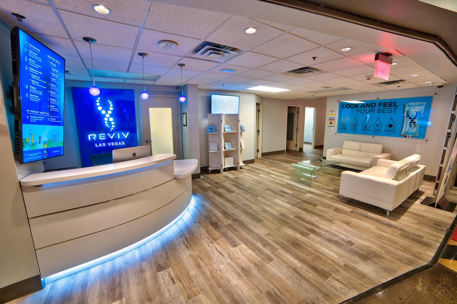 Modern reception area with curved desk and white lounge seating.