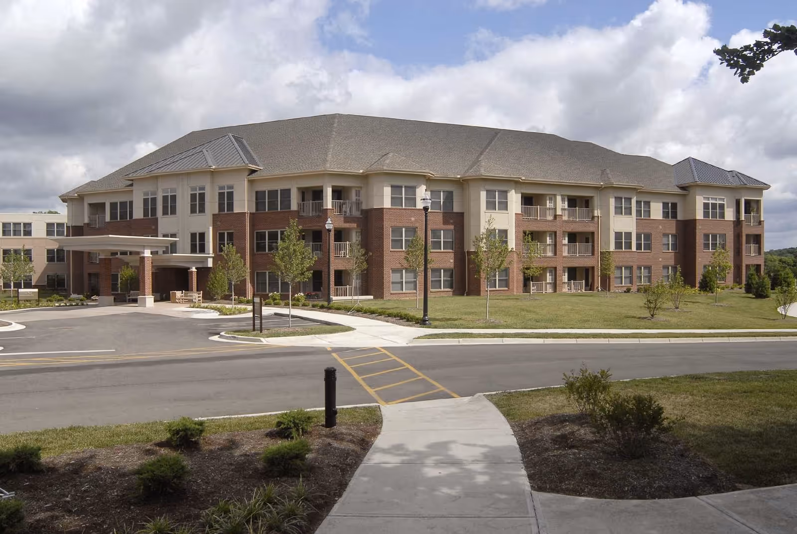 Exterior view of a Graceworks at Home senior living building with landscaping and driveway.