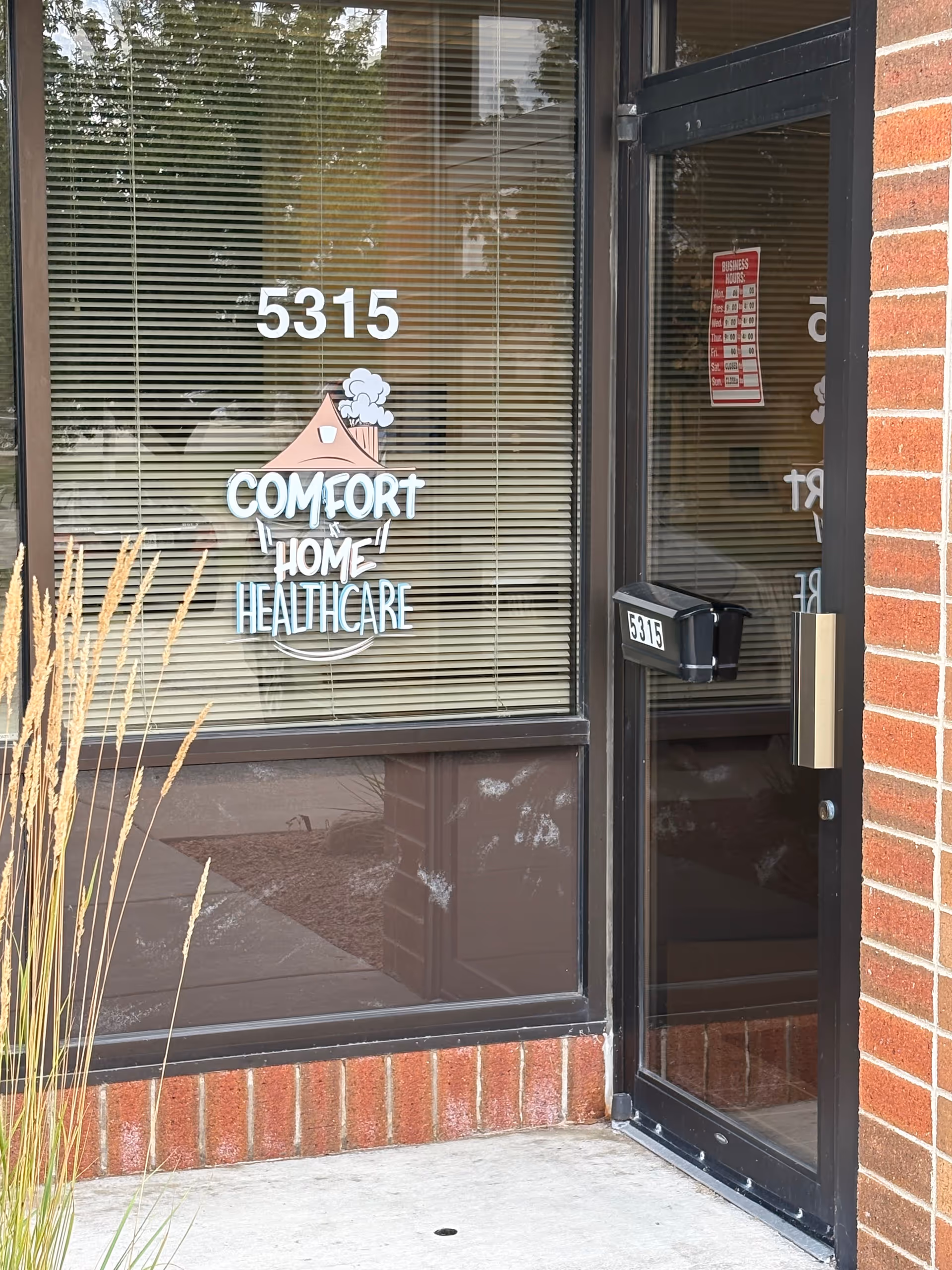 Glass storefront entrance of Comfort At Home Healthcare with logo and address 5315.