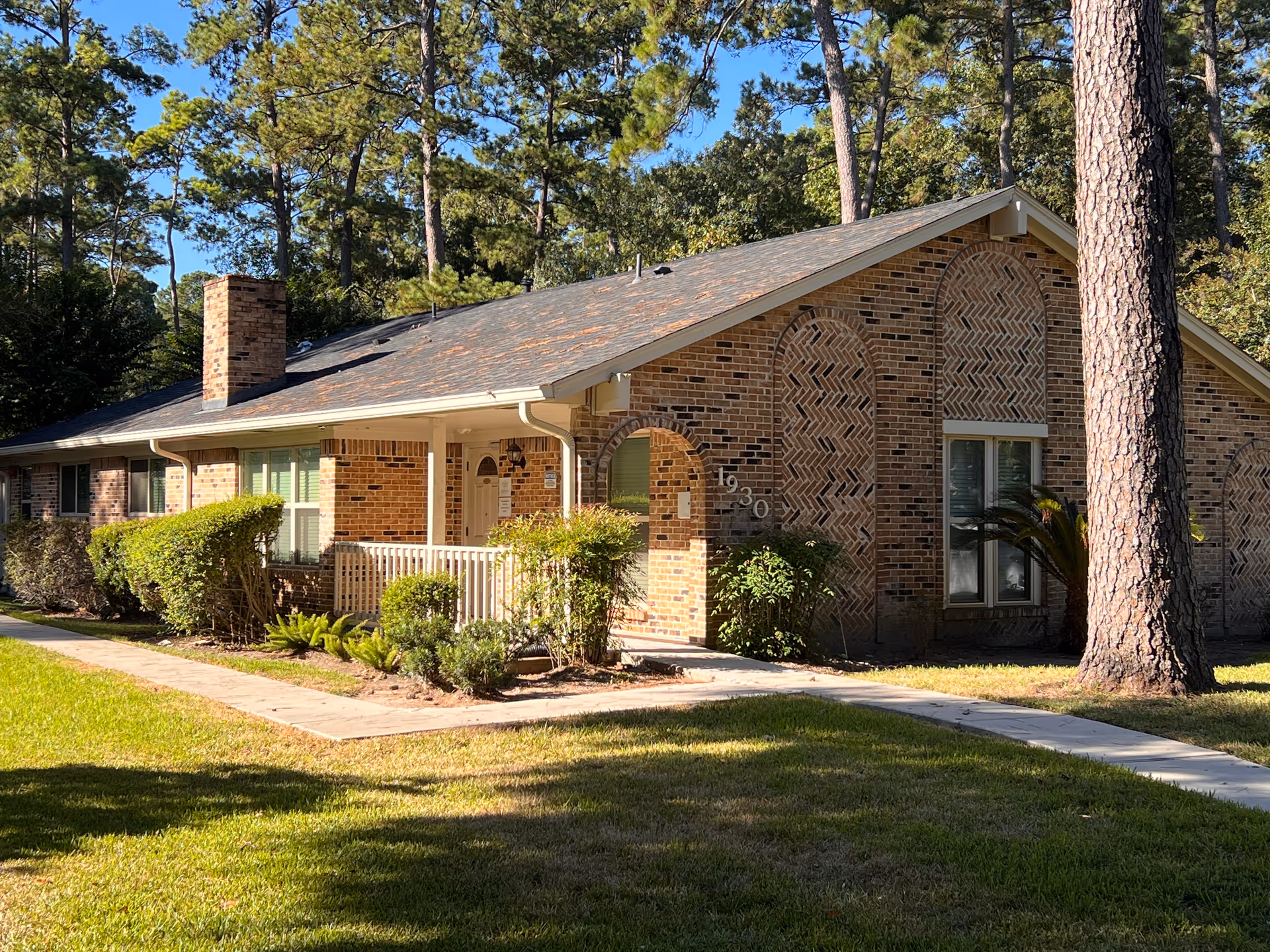 Brick, single-story senior living facility with front entrance and landscaping.