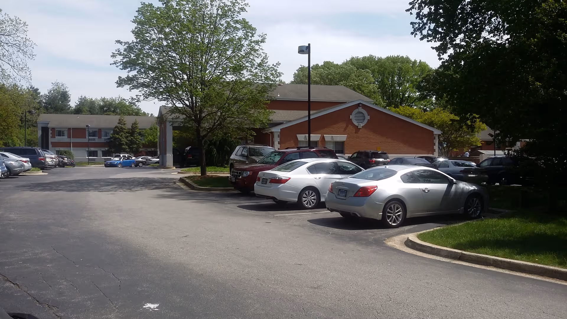 Exterior view of Autumn Lake Healthcare at Spa Creek with cars parked.