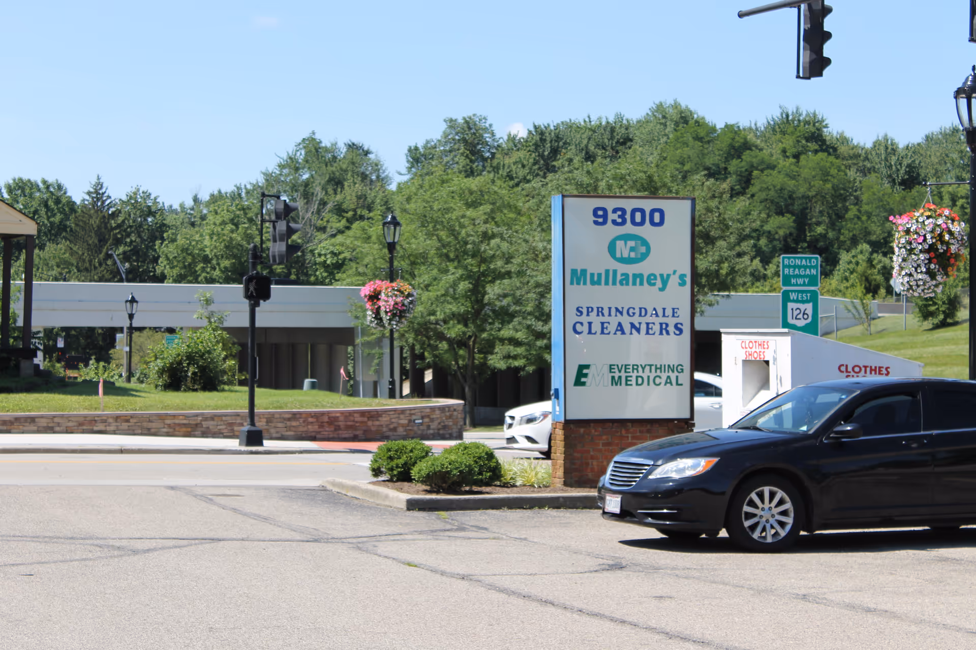 Exterior view of Mullaney's sign with a parked car and greenery at facility entrance