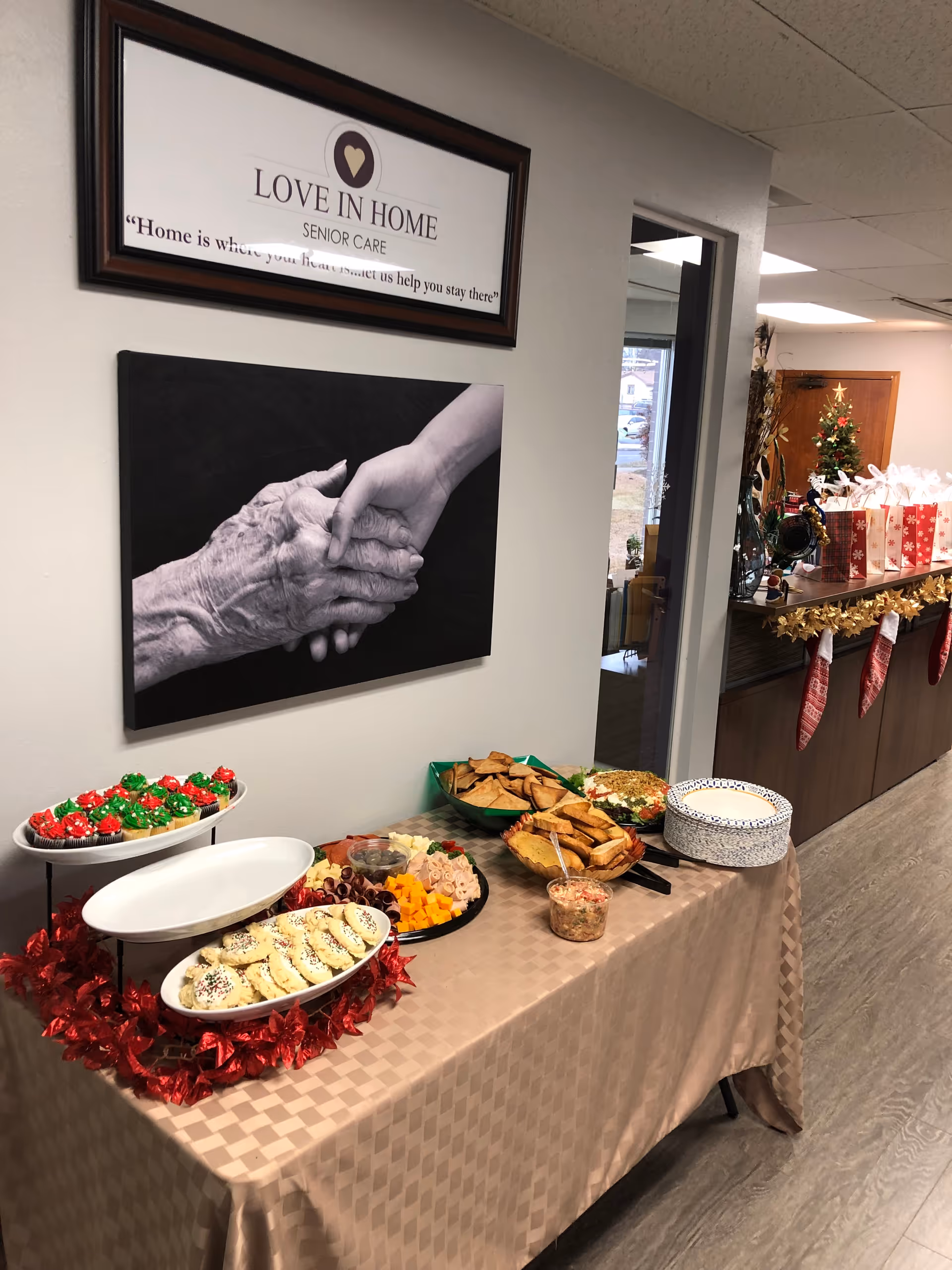 A buffet table with snacks and a Christmas display in a senior care facility.