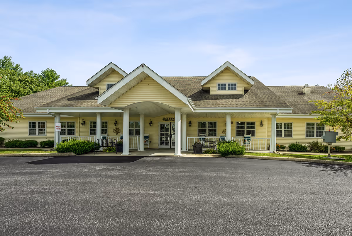 Front view of a yellow senior living facility with a covered entrance.
