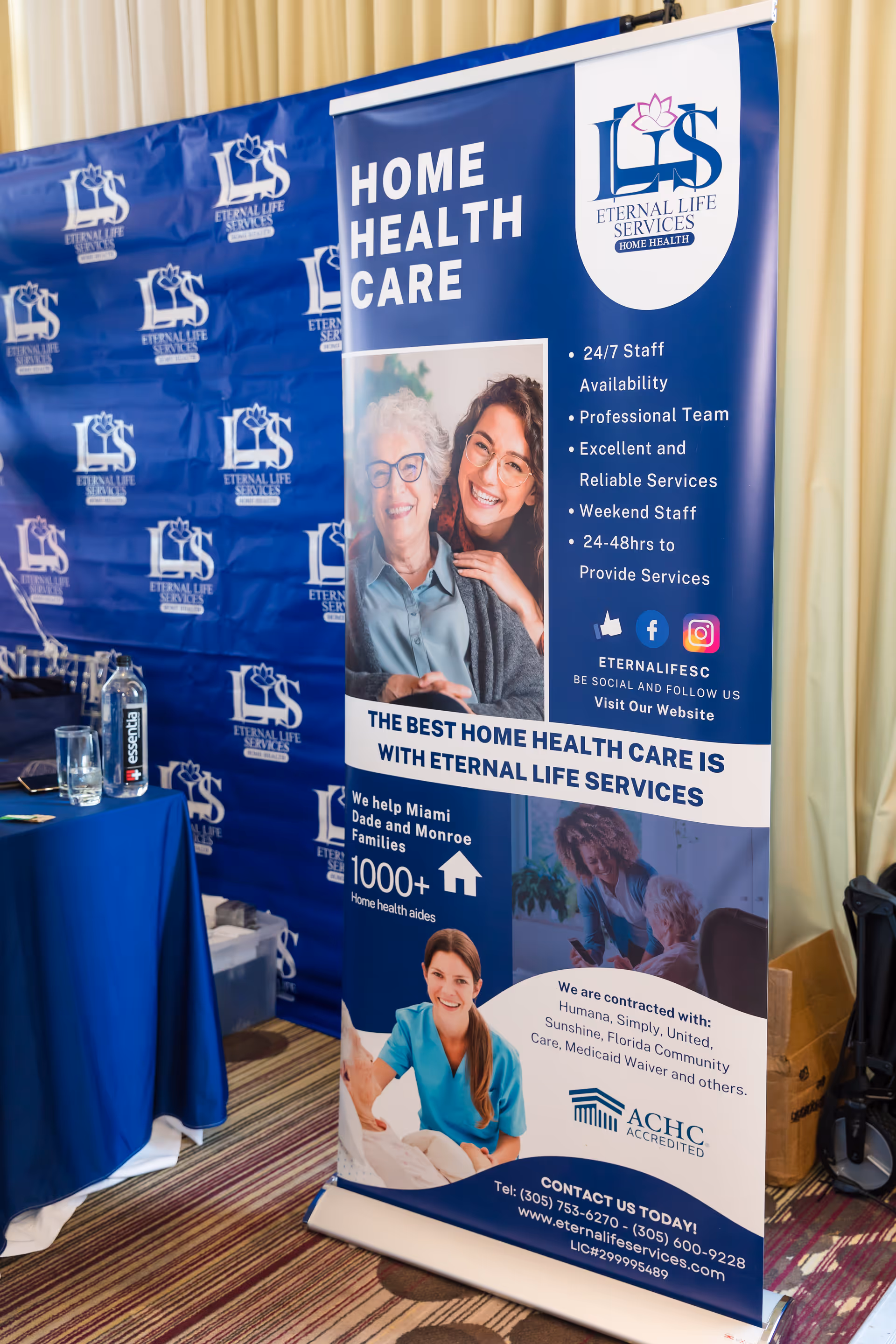 Indoor trade show booth with Eternal Life Services banners and a blue table display.