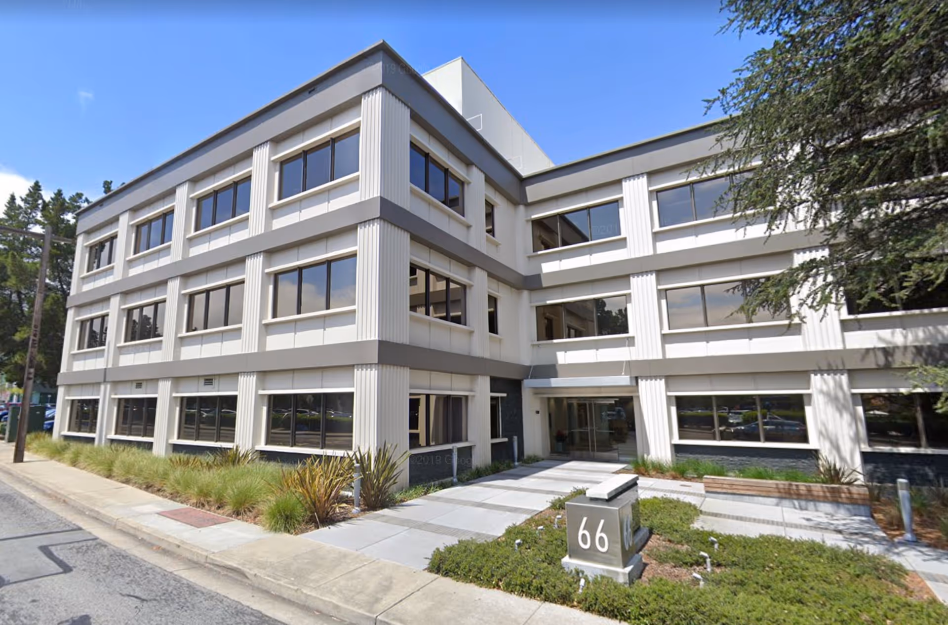 Mission Hospice & Home Care exterior: modern three-story building with large windows and landscaped entrance.