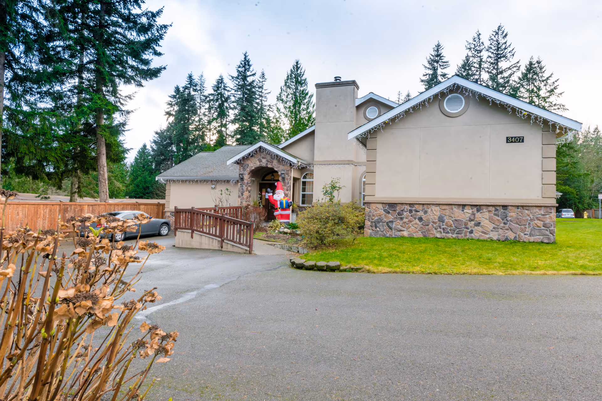 Exterior view of Pine Lake AFH facility with entrance, ramp, and surrounding trees
