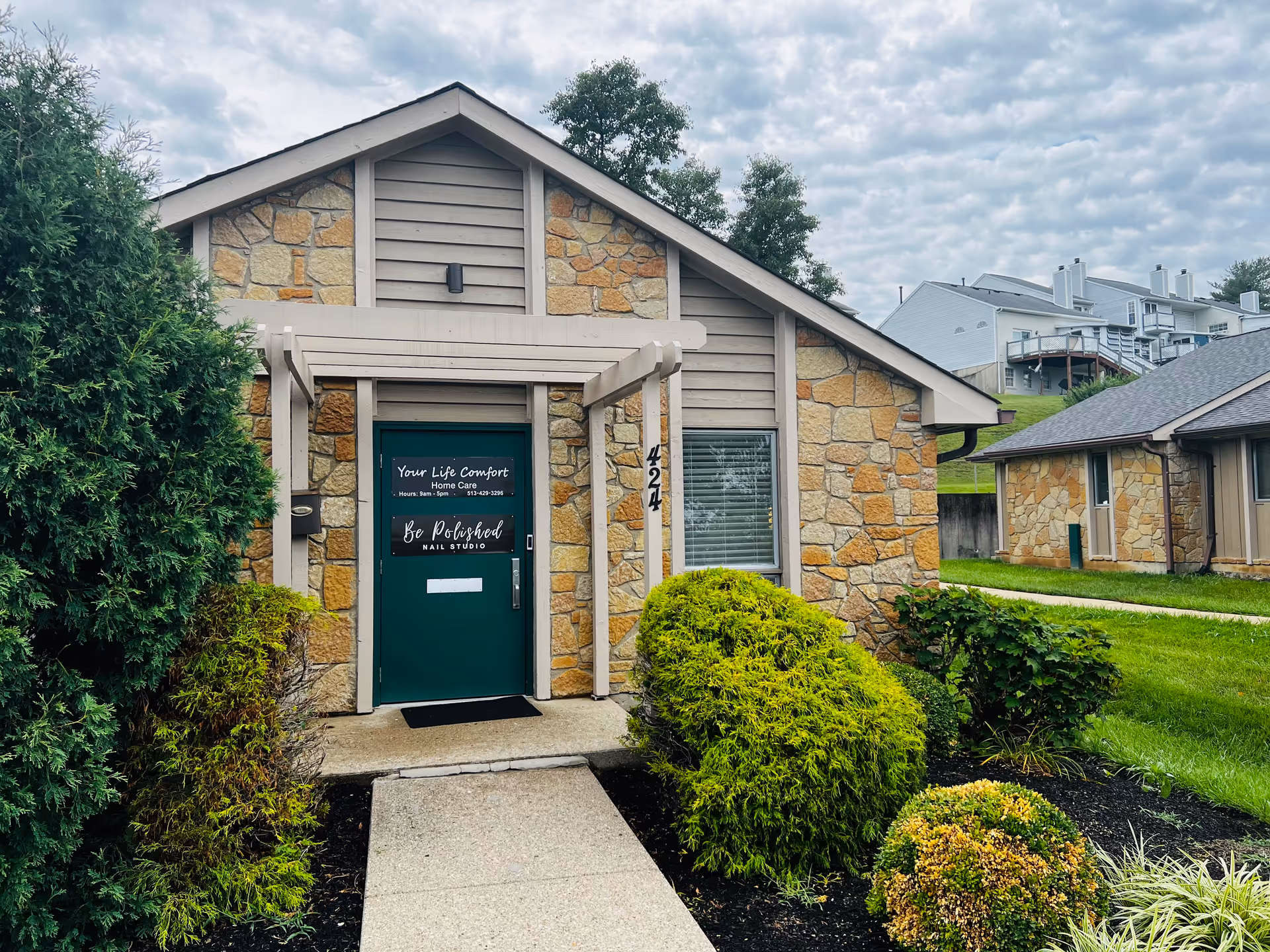 Stone building entrance with a green door and Your Life Comfort Home Care sign.